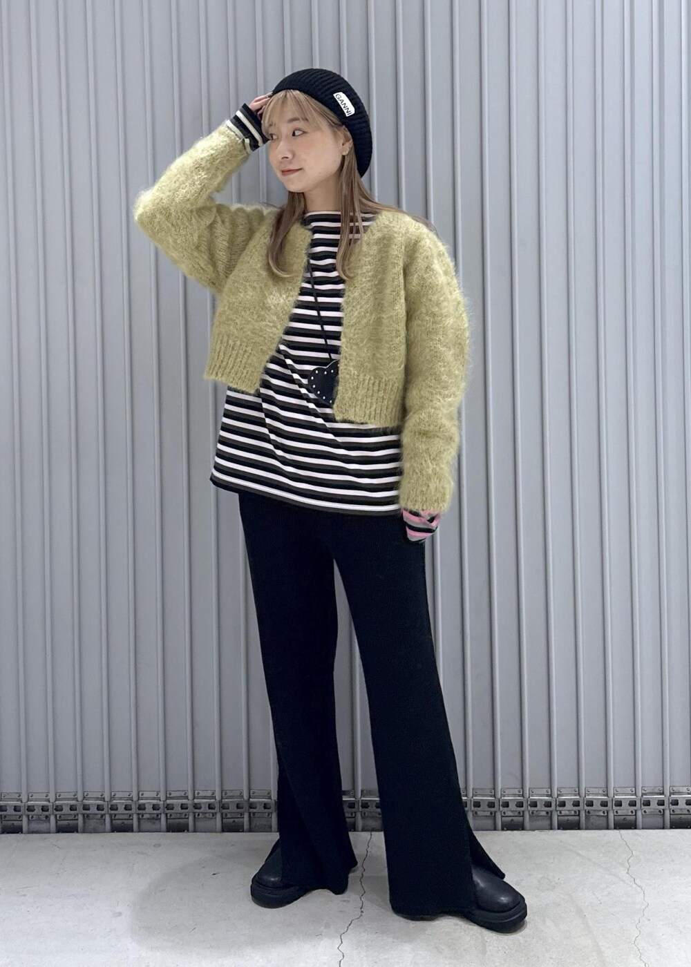 ピンク系のTシャツ/カットソー、ブラック系のブーツ、グリーン系のカーディガン/ボレロを着用したレディースの秋コーディネートの4枚目の写真