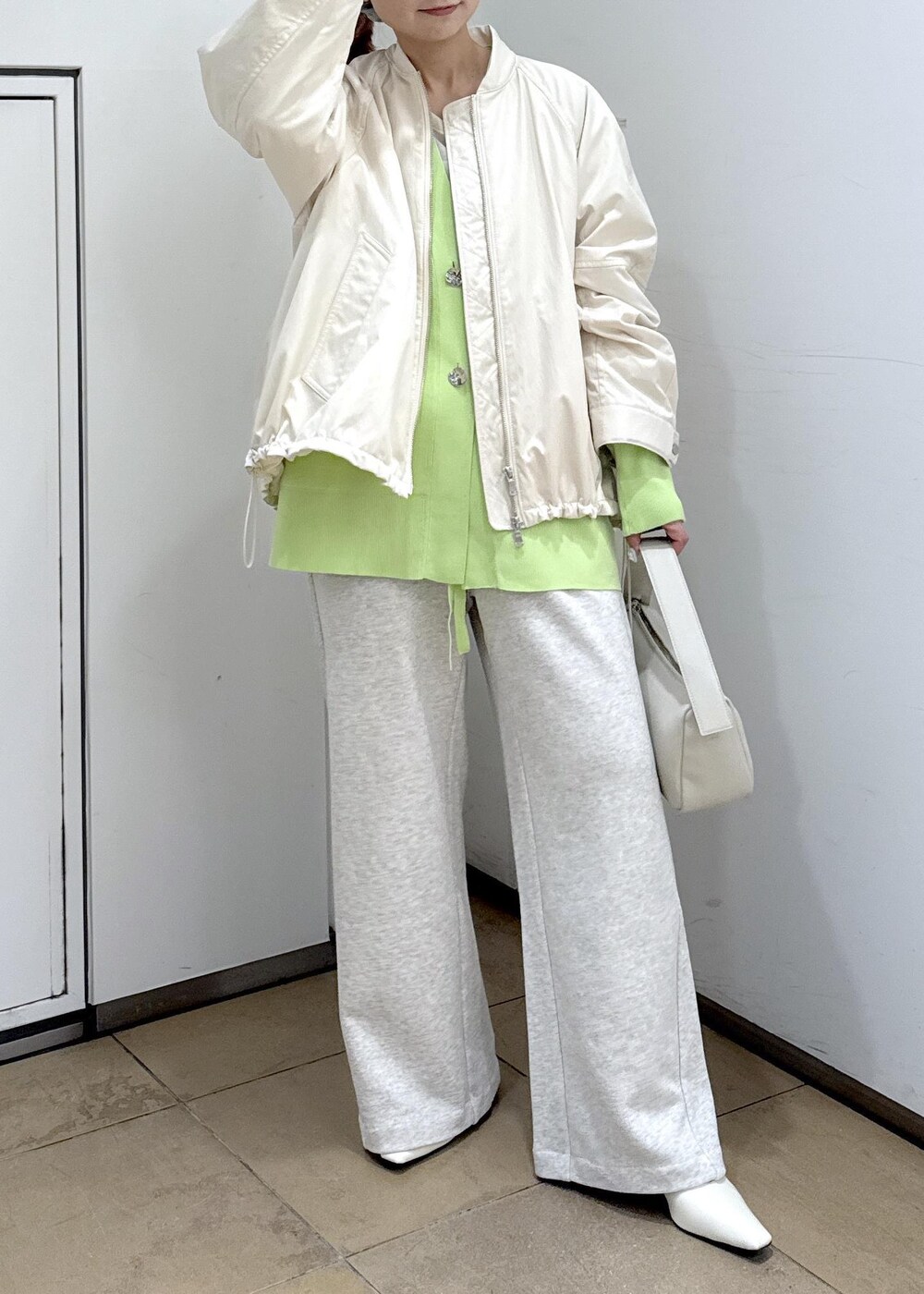 グリーン系のカーディガン/ボレロ、ホワイト系のパンプス、ホワイト系のその他パンツを着用したレディースの冬コーディネートの7枚目の写真