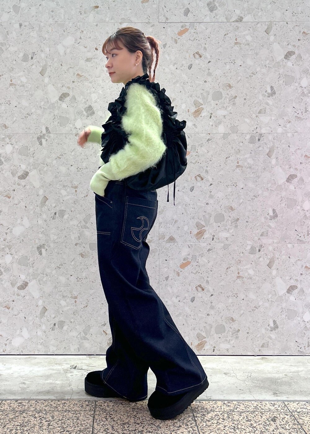 グリーン系のニット/セーター、ブルー系のデニムパンツを着用したレディースの秋コーディネートの2枚目の写真