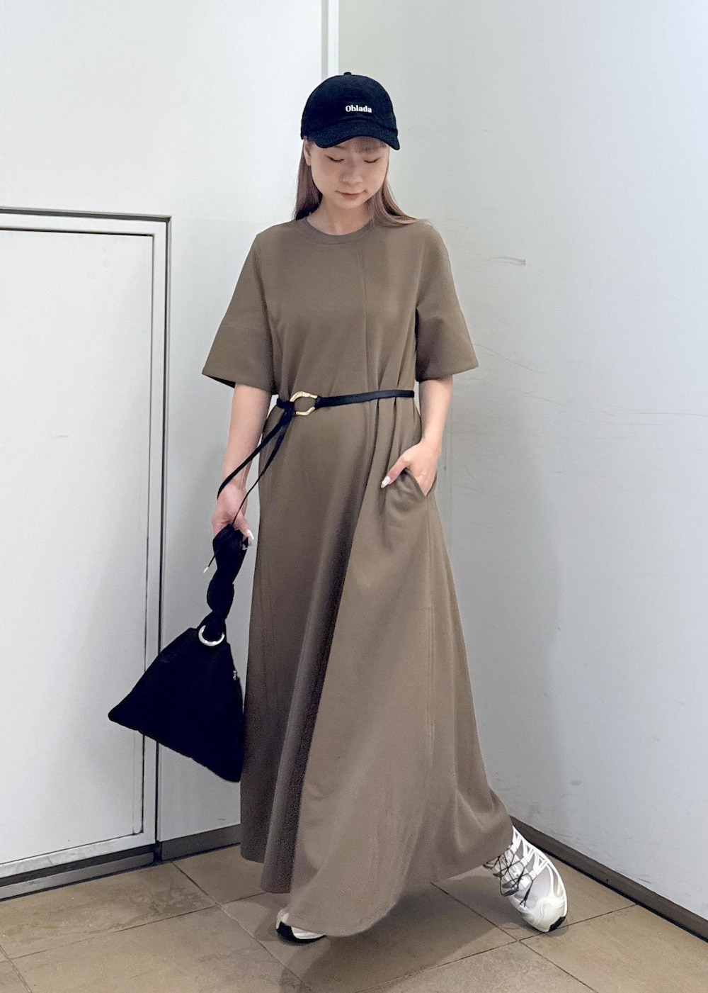 ブラウン系のワンピース、ブラック系のハンドバッグを着用したレディースの夏コーディネートの4枚目の写真