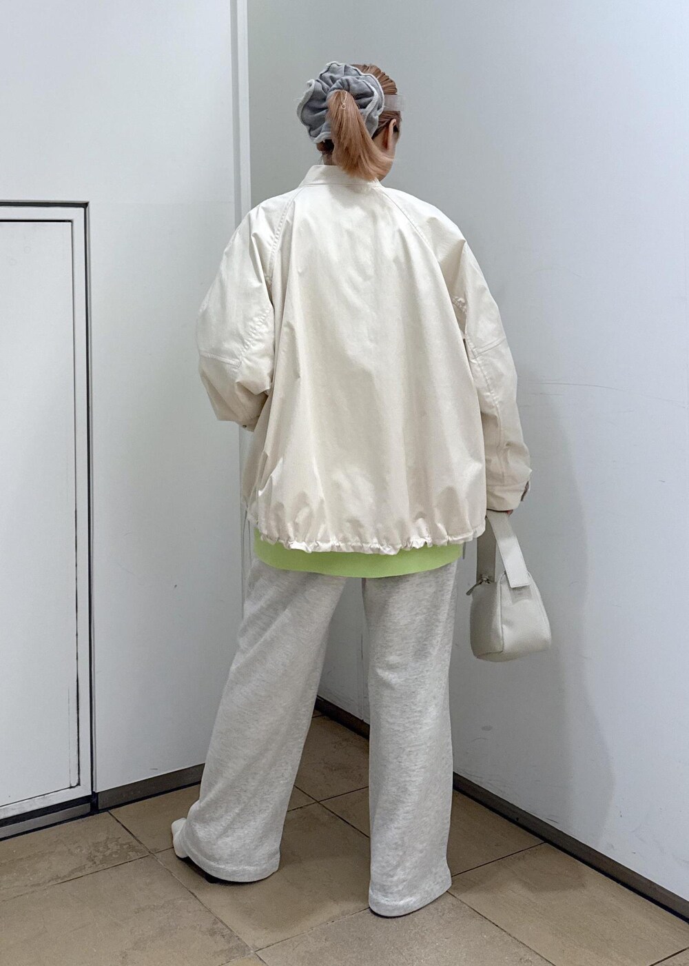 グリーン系のカーディガン/ボレロ、ホワイト系のパンプス、ホワイト系のその他パンツを着用したレディースの冬コーディネートの6枚目の写真