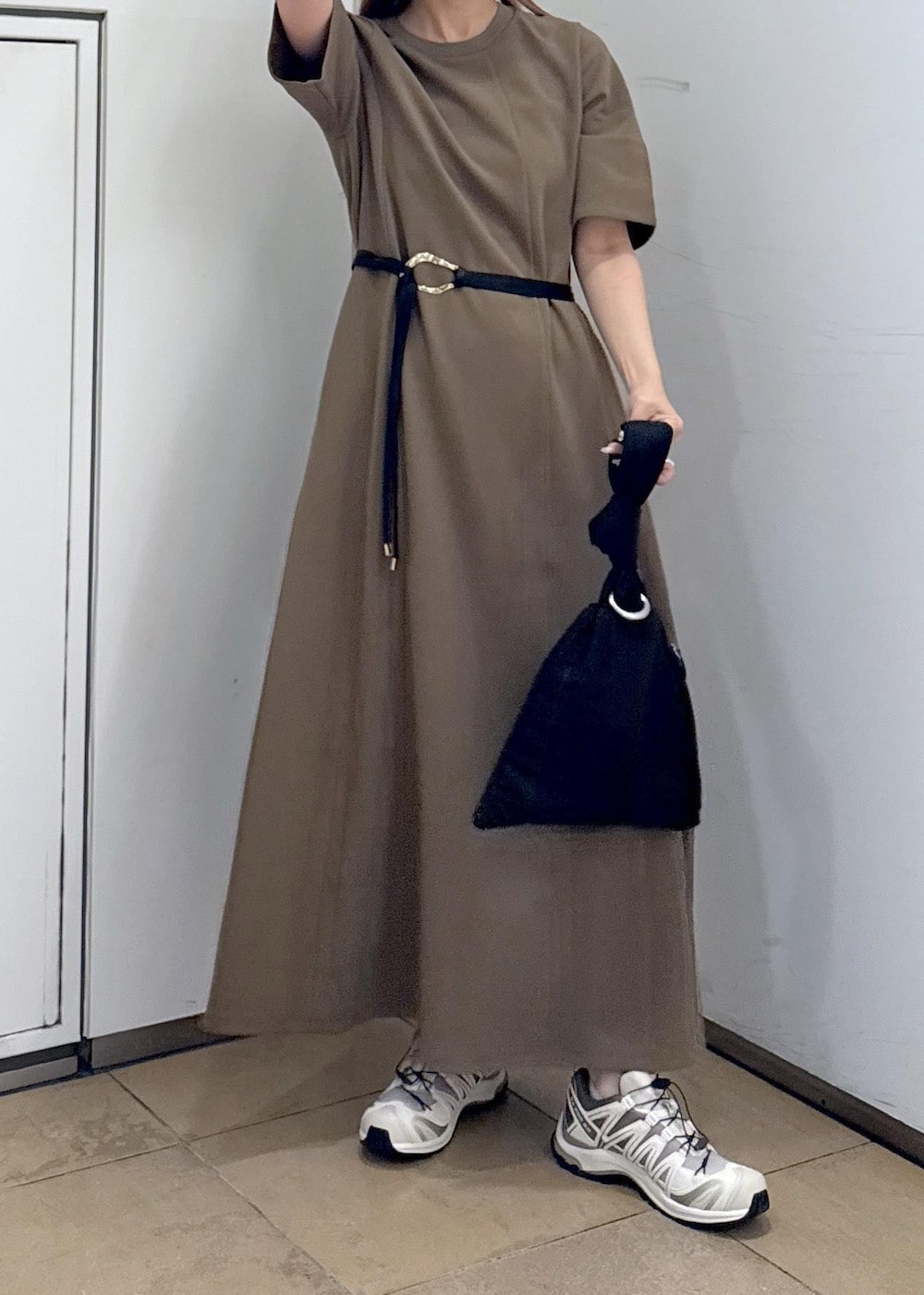 ブラウン系のワンピース、ブラック系のハンドバッグを着用したレディースの夏コーディネートの9枚目の写真