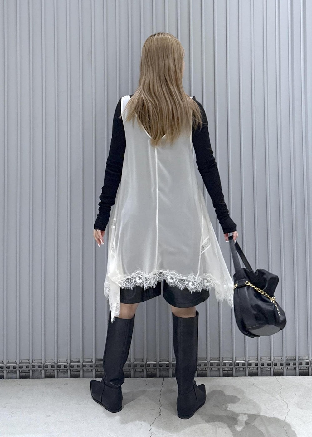 ブラック系のTシャツ/カットソー、ブラック系のブーツ、ブラック系のハンドバッグを着用したレディースの秋コーディネートの5枚目の写真