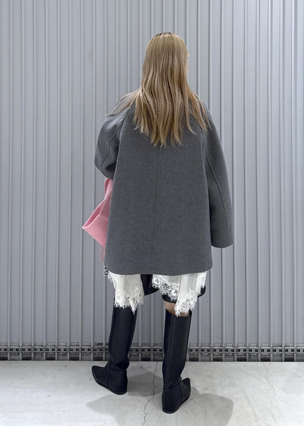 ブラック系のTシャツ/カットソー、ブラック系のブーツ、グレー系のステンカラーコートを着用したレディースの秋コーディネートの3枚目の写真