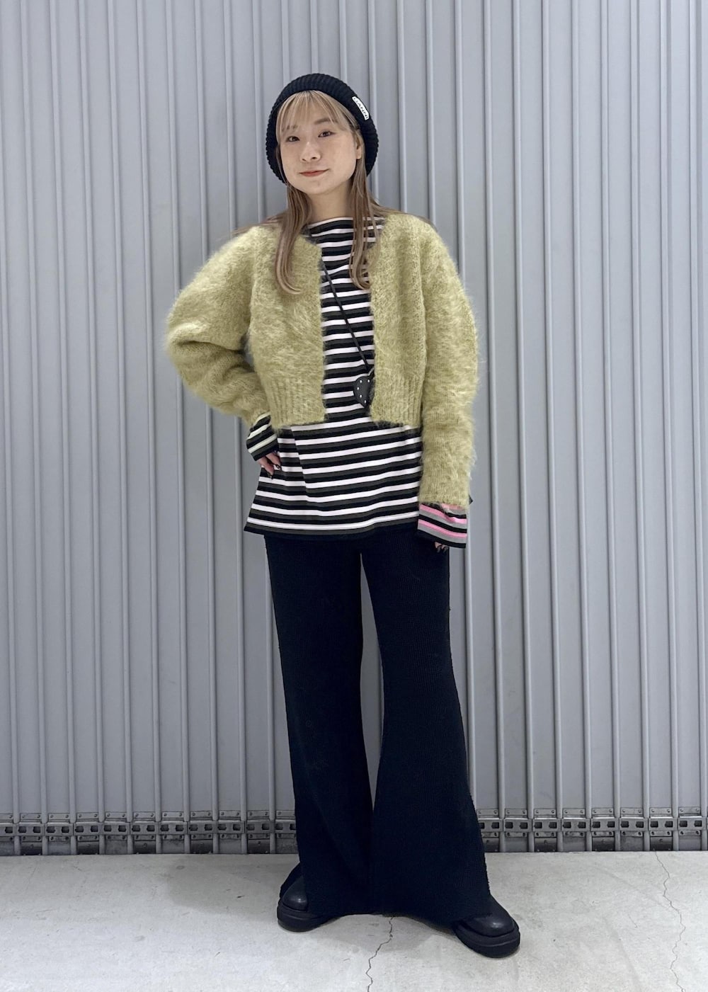 ピンク系のTシャツ/カットソー、ブラック系のブーツ、グリーン系のカーディガン/ボレロを着用したレディースの秋コーディネートの2枚目の写真