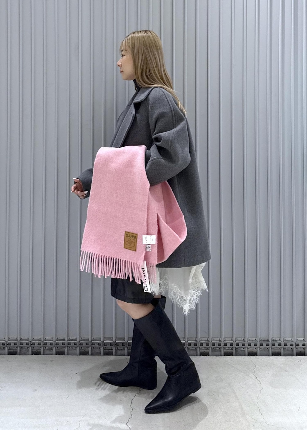 ブラック系のTシャツ/カットソー、ブラック系のブーツ、グレー系のステンカラーコートを着用したレディースの秋コーディネートの4枚目の写真