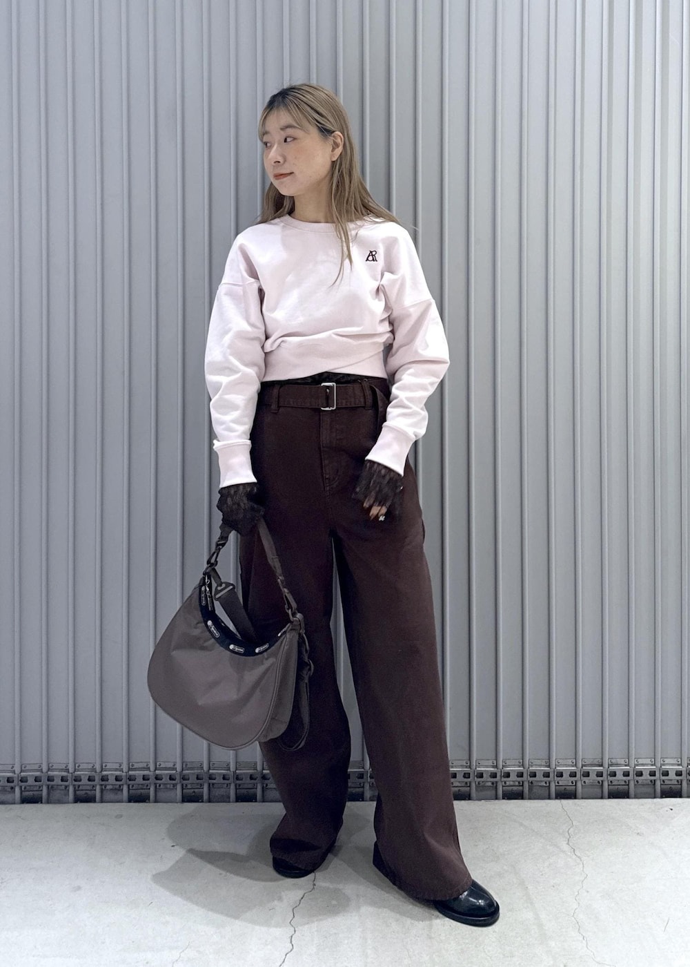 ブラック系のサンダル、ピンク系のスウェット、ブラウン系のTシャツ/カットソーを着用したレディースの冬コーディネートの3枚目の写真