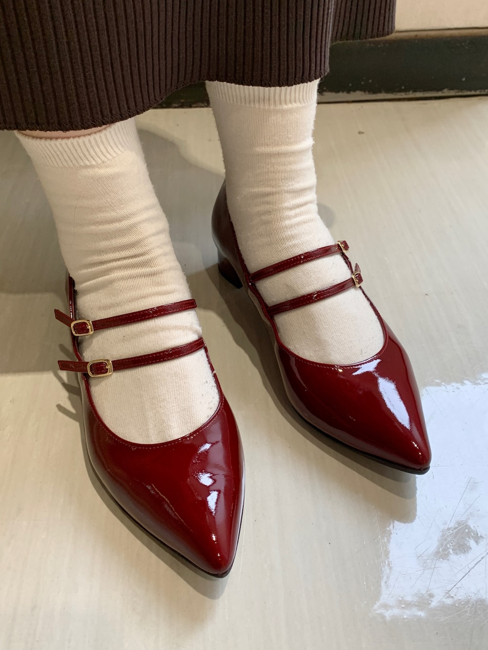 レッド系のパンプスを着用したレディースの秋コーディネートの2枚目の写真