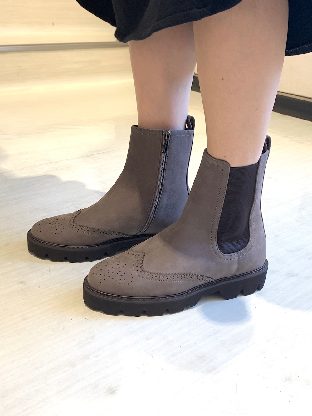 グレー系のブーツを着用したレディースの秋コーディネートの2枚目の写真