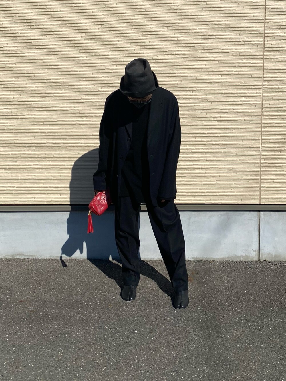 ブラック系のパンツ、ブラック系のジャケット/アウター、レッド系のバッグを着用したレディースの春コーディネートの2枚目の写真