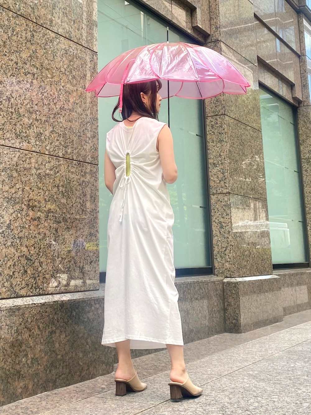 ホワイト系のワンピース、イエロー系のニット/セーター、ピンク系の長傘を着用したレディースの夏コーディネートの2枚目の写真