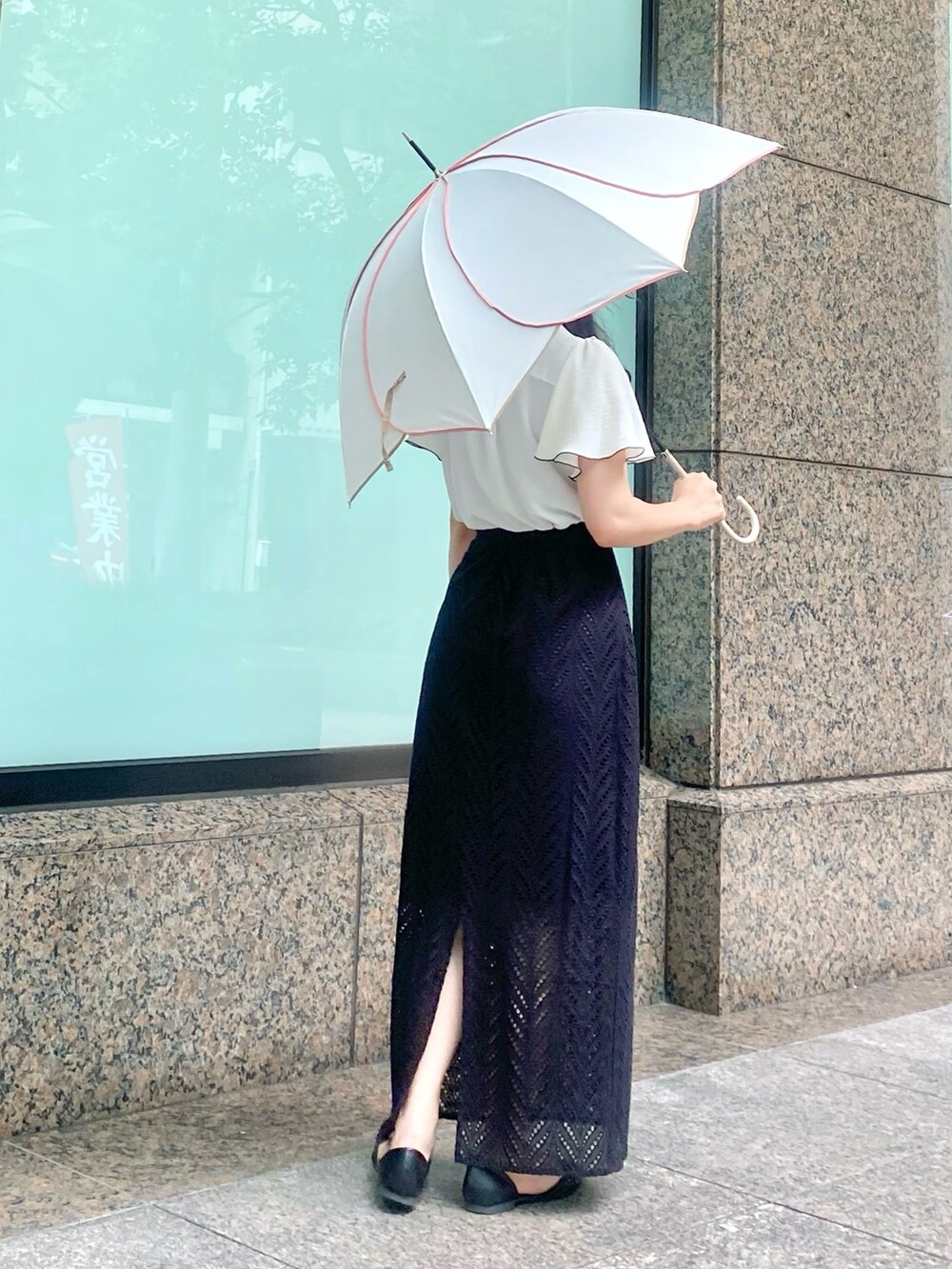 ホワイト系のシャツ/ブラウス、ブラック系のスカート、ホワイト系の長傘を着用したレディースの夏コーディネートの2枚目の写真