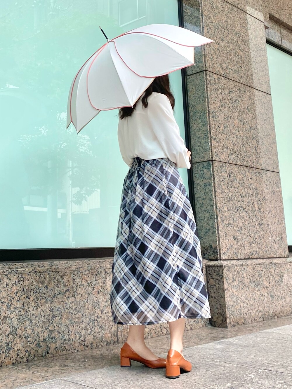 ブラック系のスカート、ホワイト系のシャツ/ブラウス、ホワイト系の長傘を着用したレディースの夏コーディネートの2枚目の写真