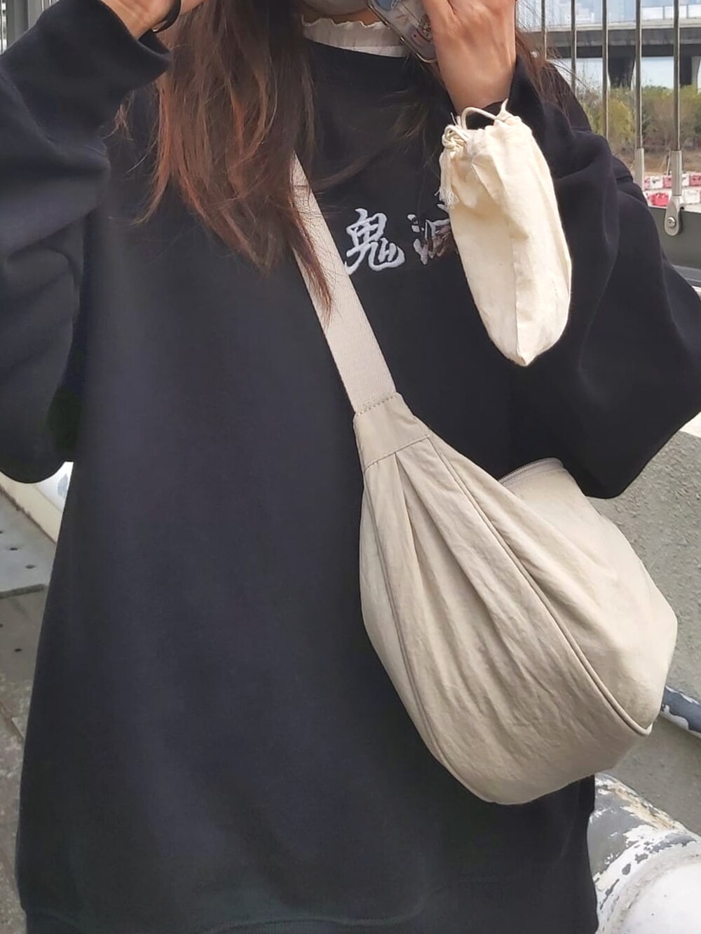 ブラック系のトップス、ブラウン系のスカート、ブラック系のスニーカーを着用したレディースの春コーディネートの2枚目の写真