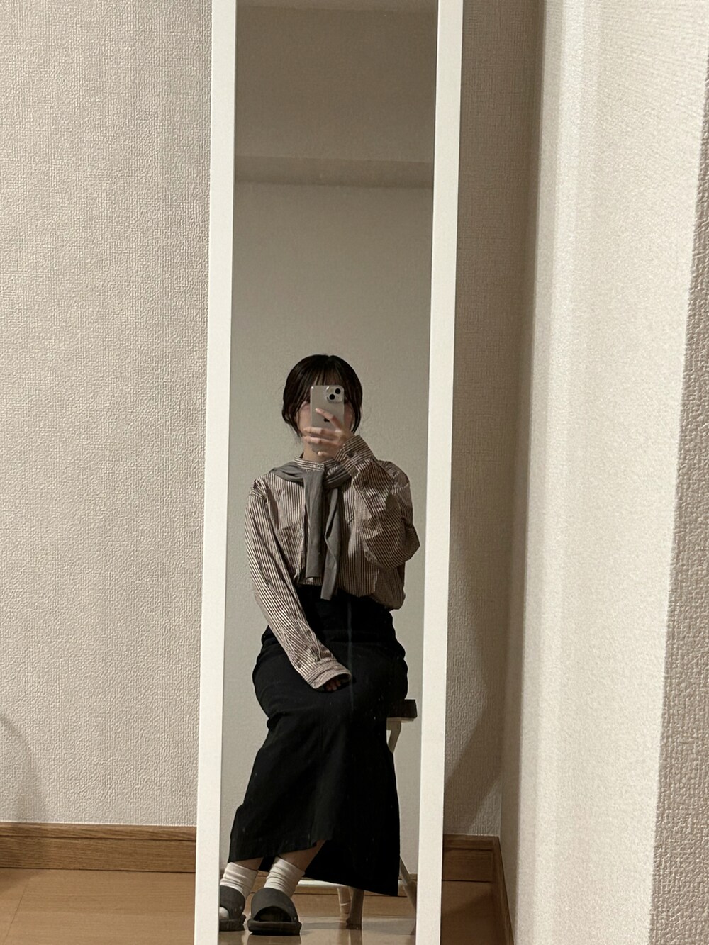ブラック系のスカート、ホワイト系のジャケット/アウター、ブラウン系のカーディガン/ボレロを着用したレディースの春コーディネートの2枚目の写真