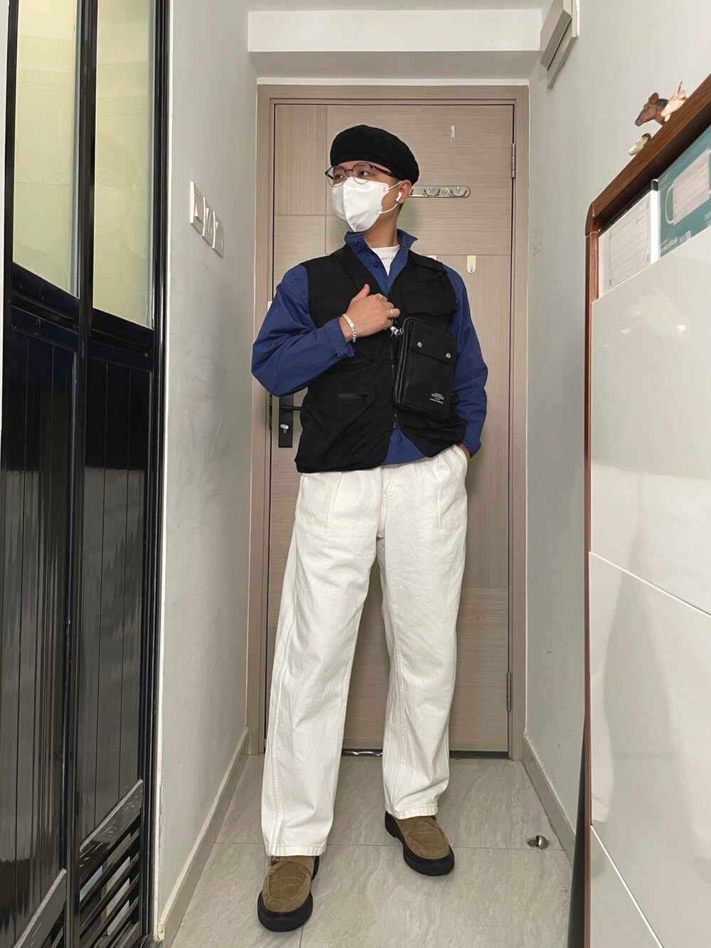 ホワイト系のパンツ、ブルー系のトップス、ブラック系のショルダーバッグを着用したメンズの春コーディネートの2枚目の写真