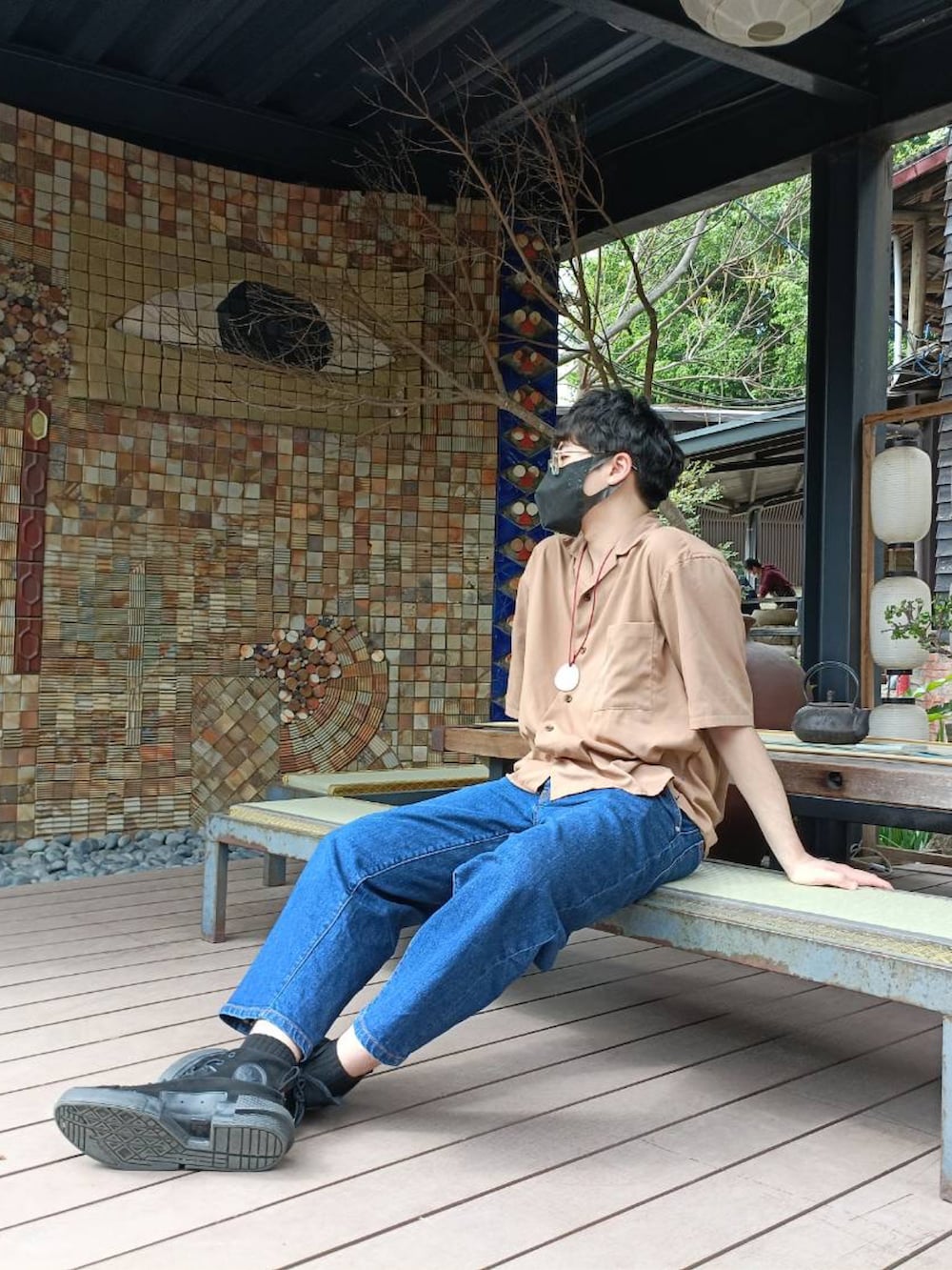 ブラック系のマウンテンパーカー、ブラウン系のシャツ/ブラウス、ブルー系のデニムパンツを着用したメンズの冬コーディネートの3枚目の写真