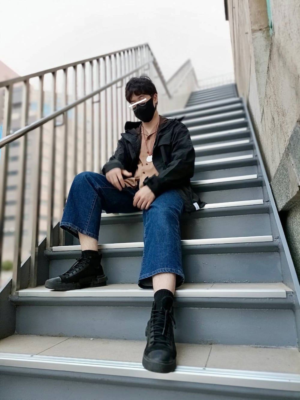 ブラック系のマウンテンパーカー、ブラウン系のシャツ/ブラウス、ブルー系のデニムパンツを着用したメンズの冬コーディネートの2枚目の写真