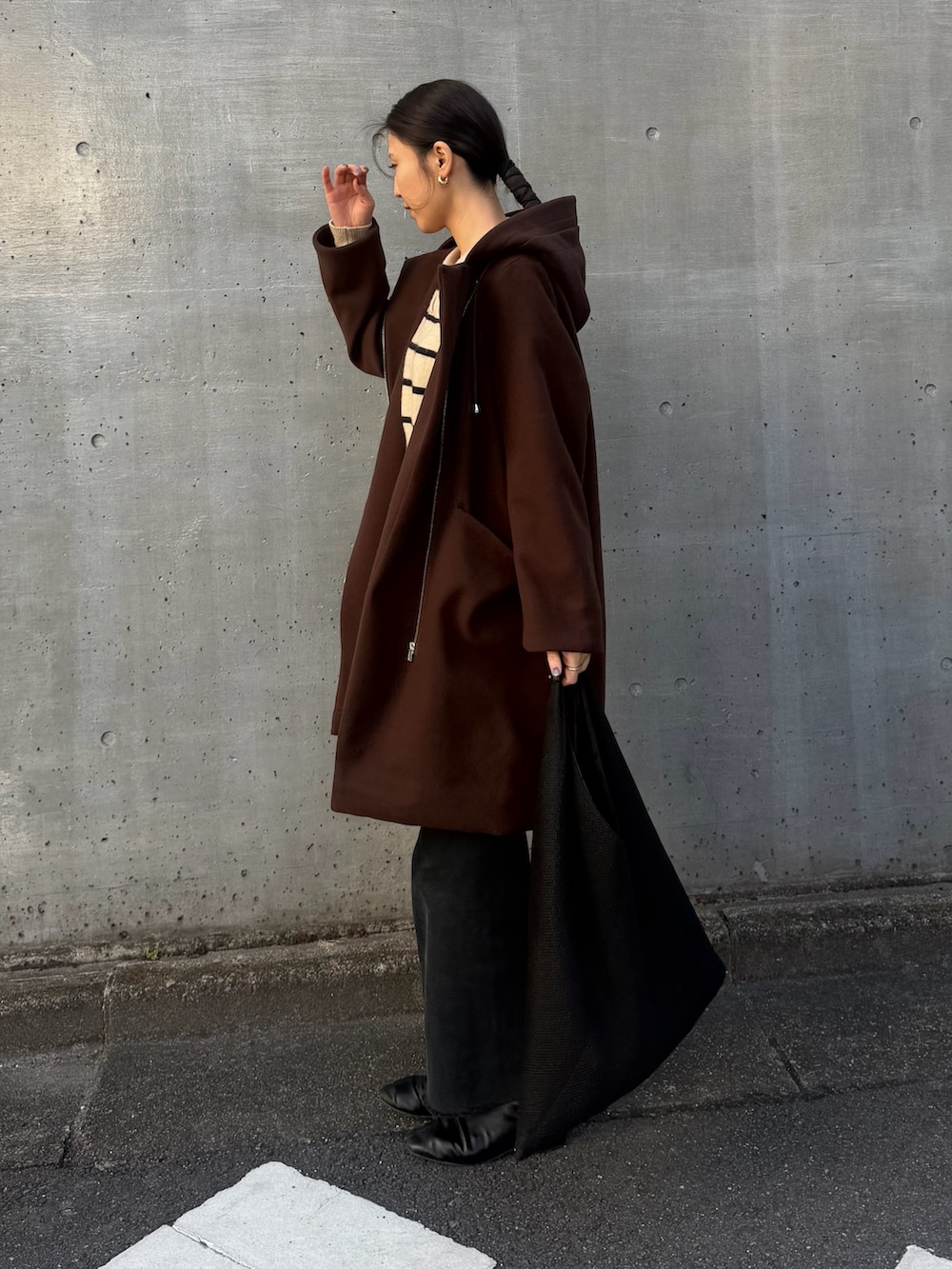 ブラウン系のその他アウター、ブラック系のデニムパンツ、ブラック系のブーツを着用したレディースの冬コーディネートの2枚目の写真