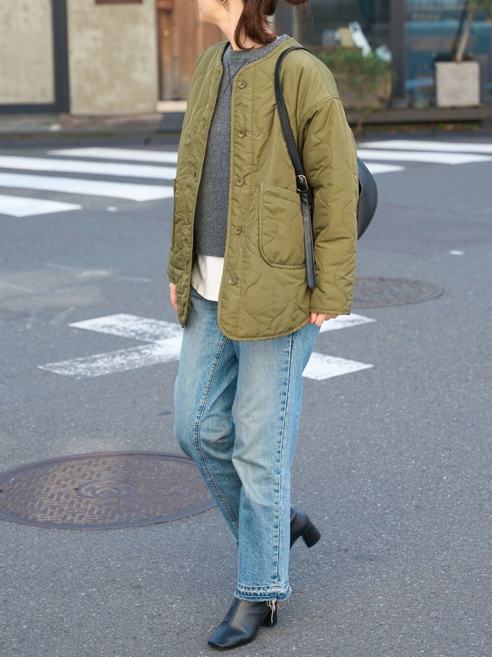 グリーン系のノーカラージャケットを着用したレディースの秋コーディネートの2枚目の写真