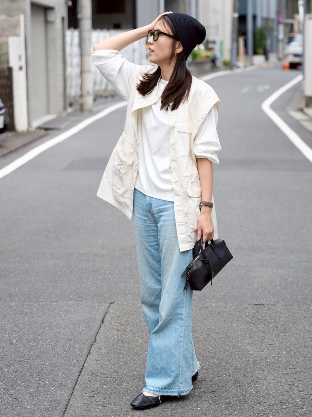 ホワイト系のTシャツ/カットソー、ホワイト系のベスト、ブルー系のデニムパンツを着用したレディースの秋コーディネートの3枚目の写真