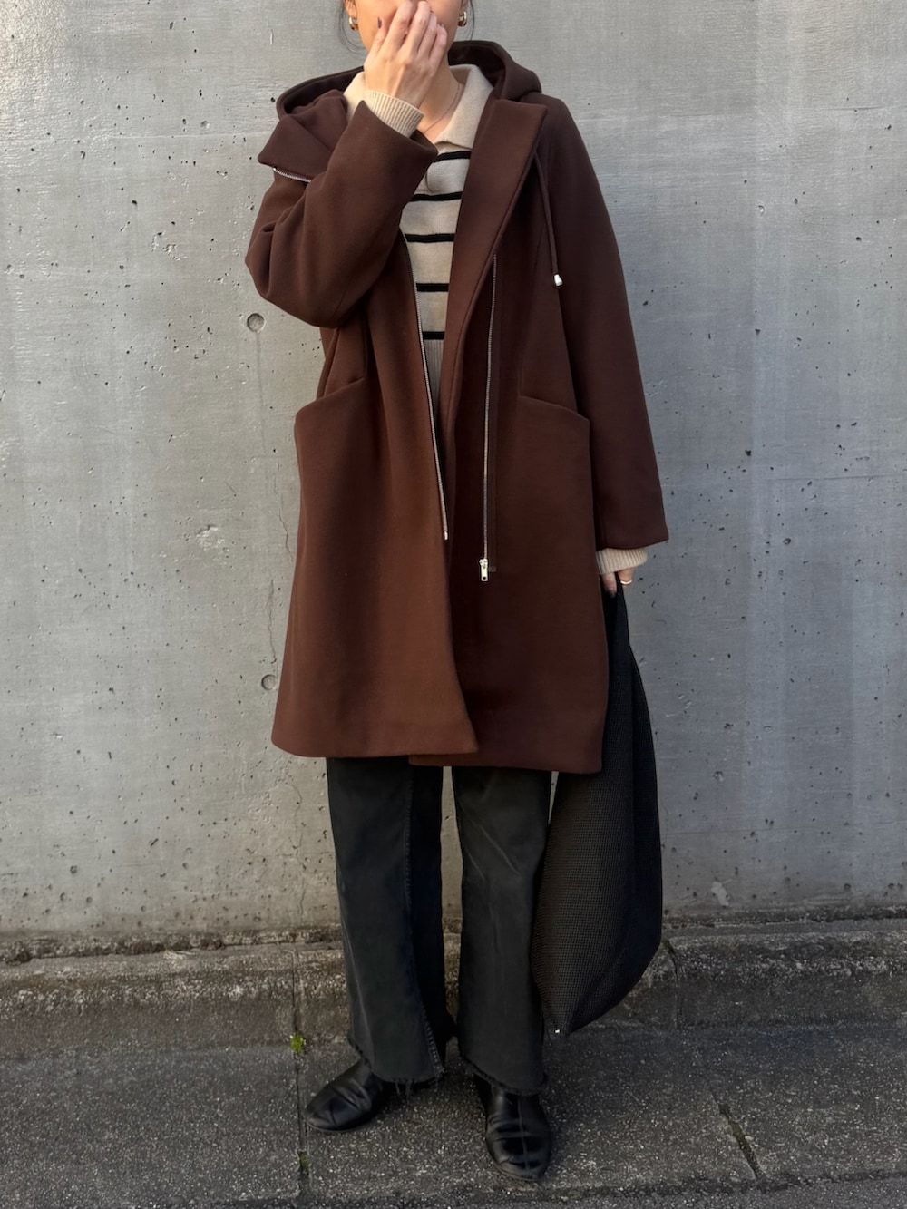 ブラウン系のその他アウター、ブラック系のデニムパンツ、ブラック系のブーツを着用したレディースの冬コーディネートの3枚目の写真