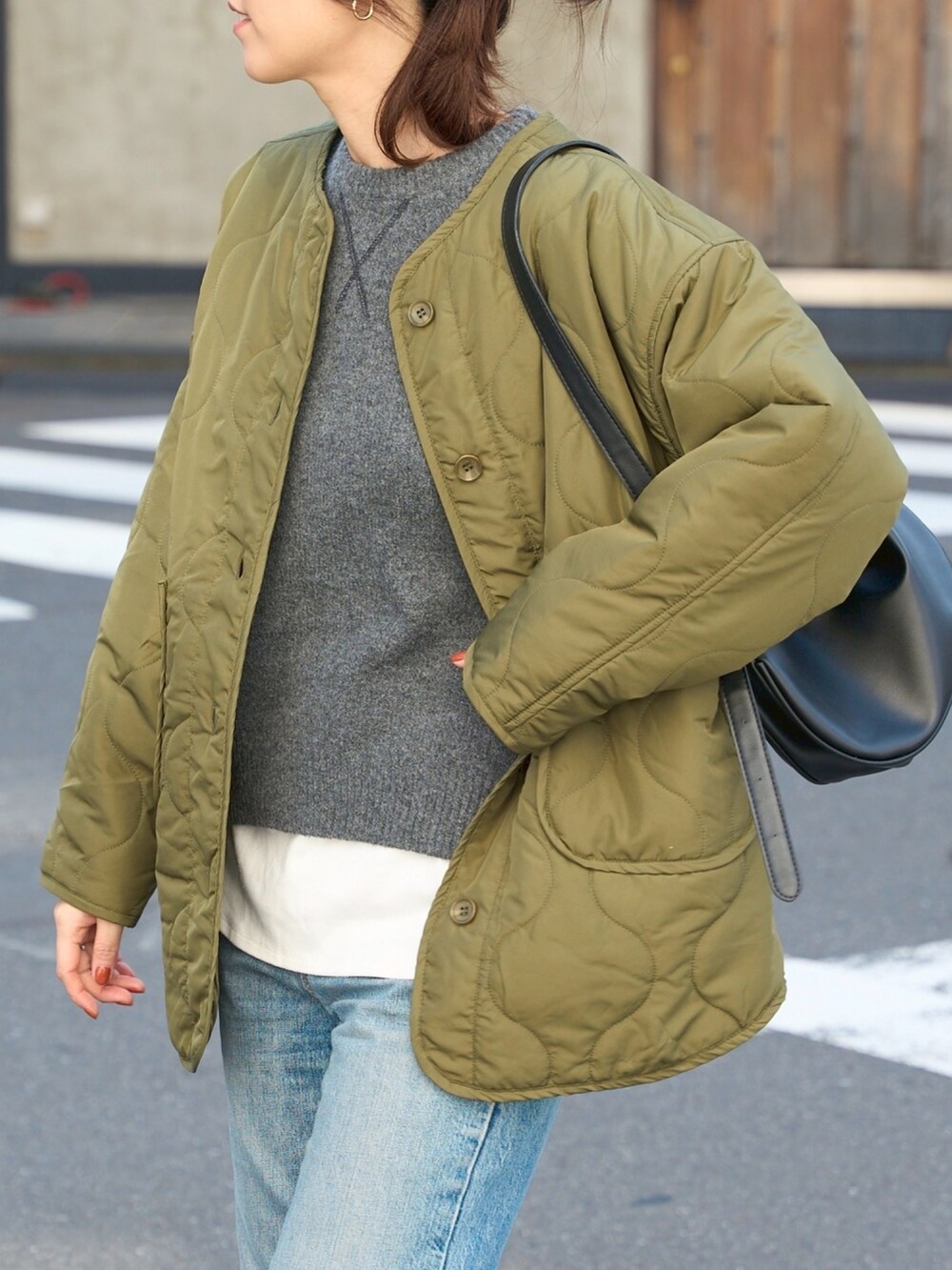 グリーン系のノーカラージャケットを着用したレディースの秋コーディネートの3枚目の写真