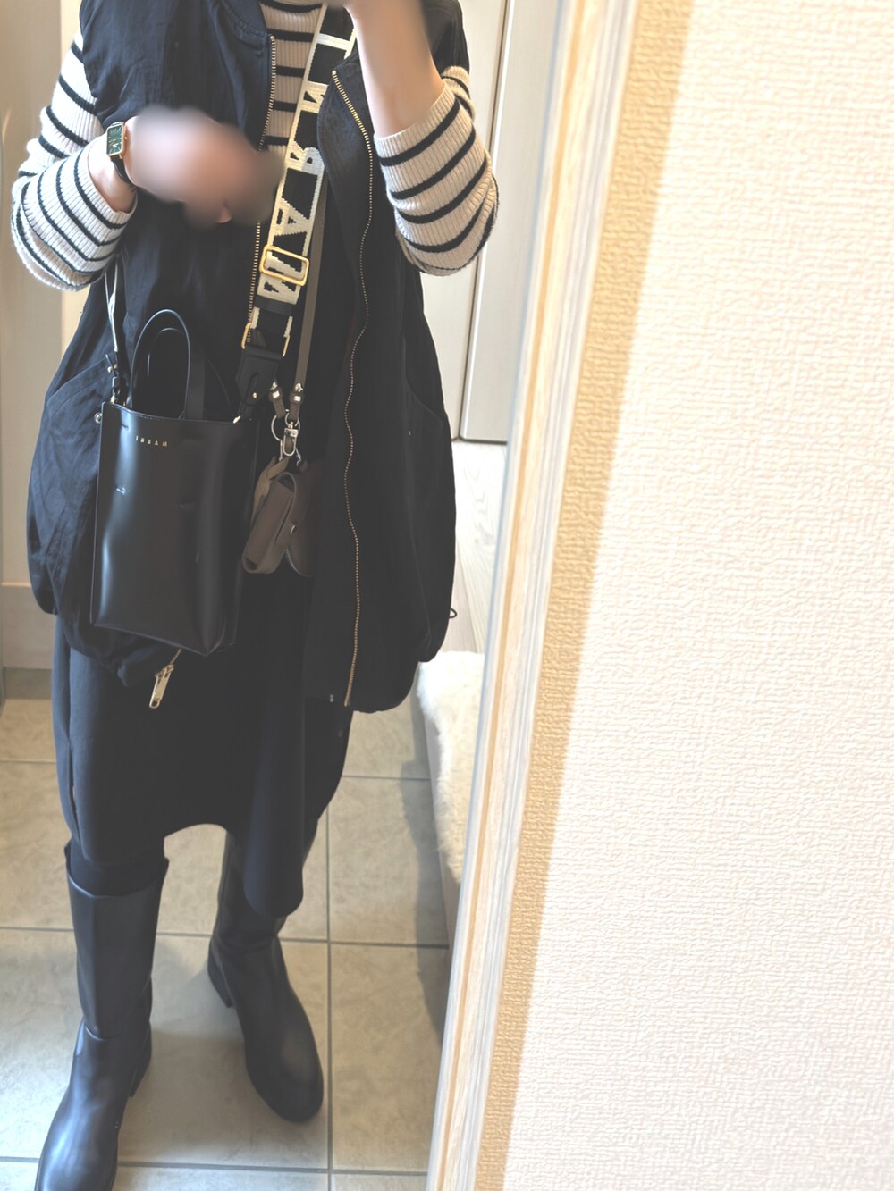 ベージュ系のショルダーバッグ、ブラック系のブーツ、ブラック系のショルダーバッグを着用したレディースの冬コーディネートの3枚目の写真