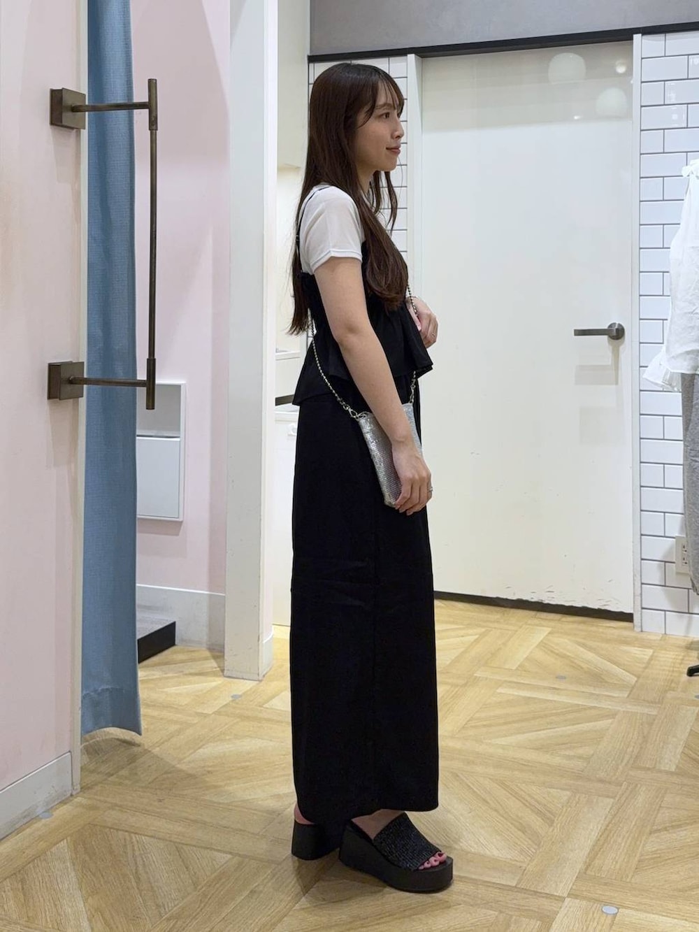 シルバー系のショルダーバッグ、ブラック系のスカート、ホワイト系のTシャツ/カットソーを着用したレディースの秋コーディネートの3枚目の写真