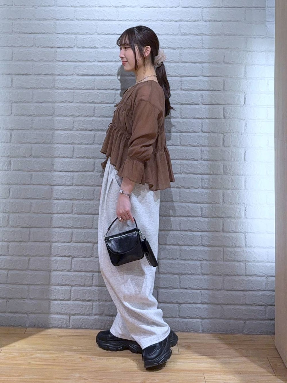 ブラック系のショルダーバッグ、ブラウン系のシャツ/ブラウス、グレー系のスウェットパンツを着用したレディースの春コーディネートの4枚目の写真