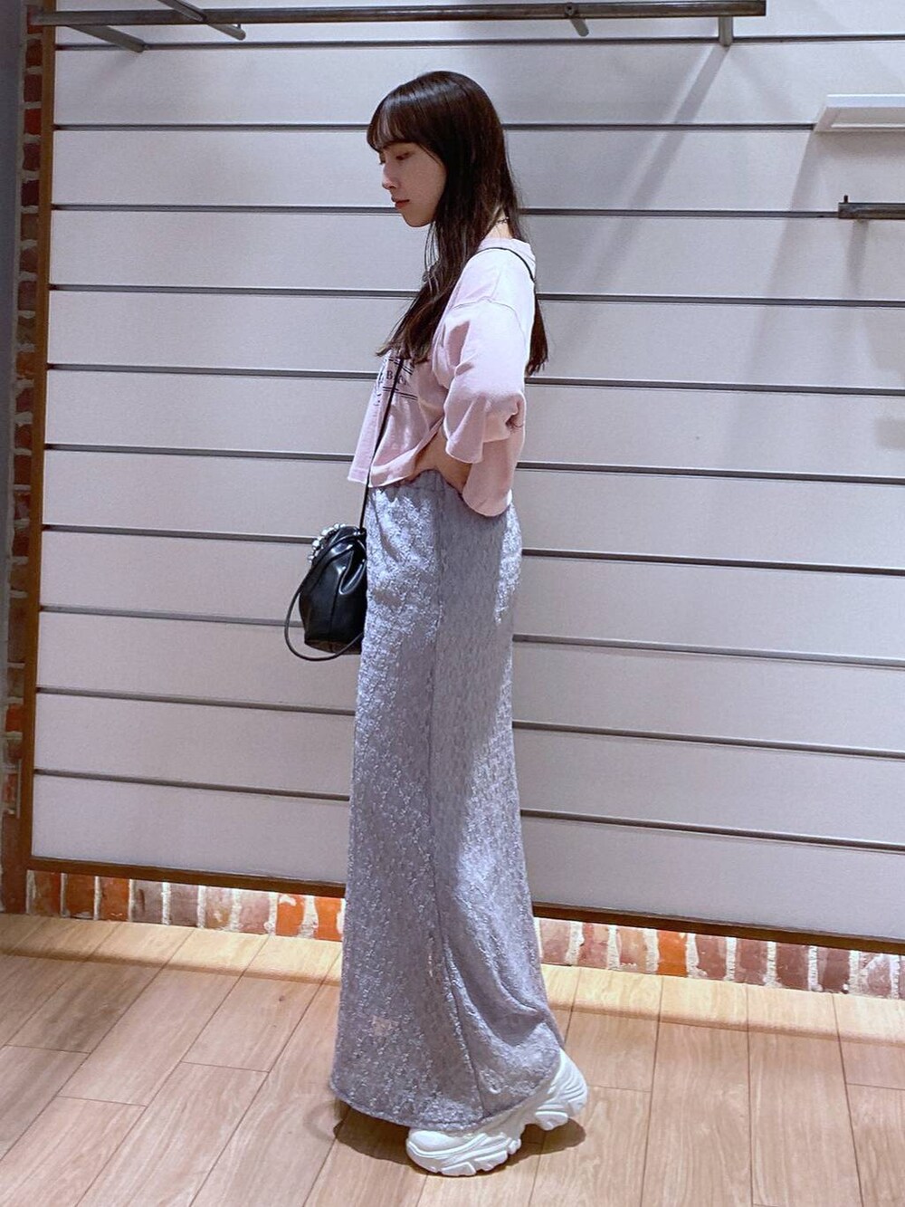 ピンク系のTシャツ/カットソー、グレー系のスカート、ブラック系のショルダーバッグを着用したレディースの夏コーディネートの5枚目の写真