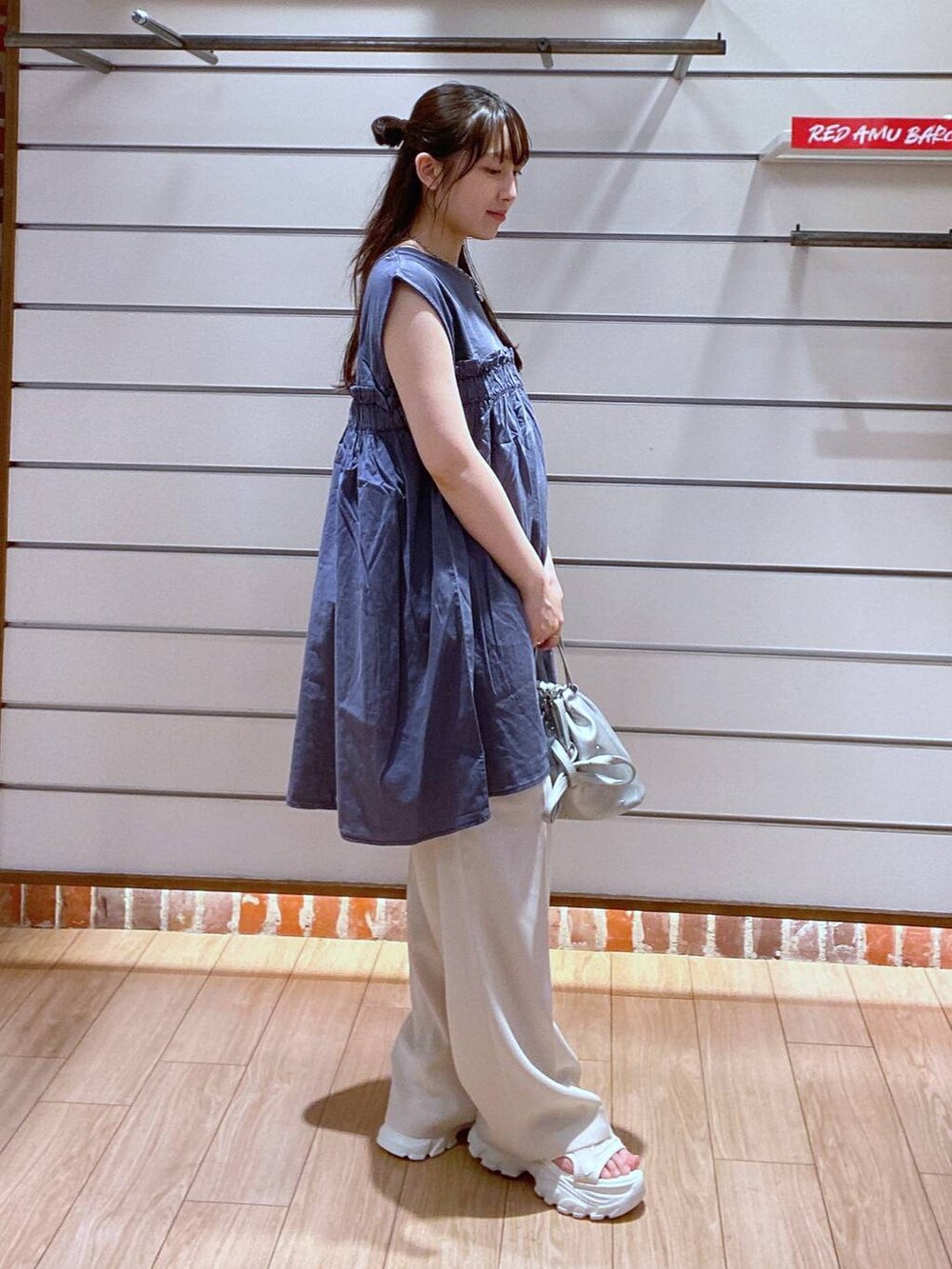 ホワイト系のサンダル、シルバー系のショルダーバッグ、ホワイト系のスラックスを着用したレディースの夏コーディネートの4枚目の写真