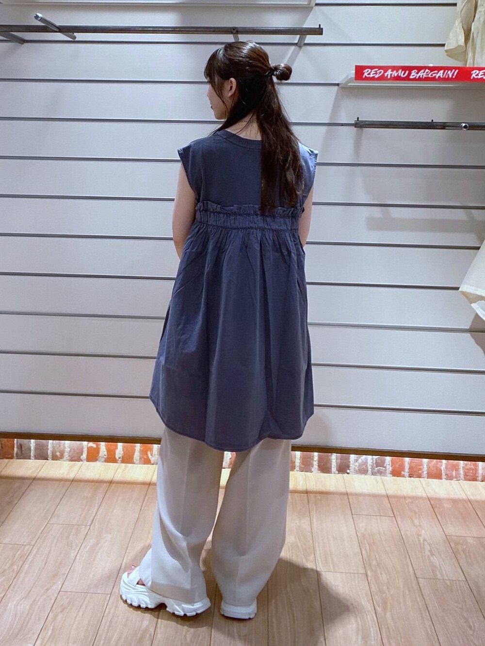 ホワイト系のサンダル、シルバー系のショルダーバッグ、ホワイト系のスラックスを着用したレディースの夏コーディネートの5枚目の写真