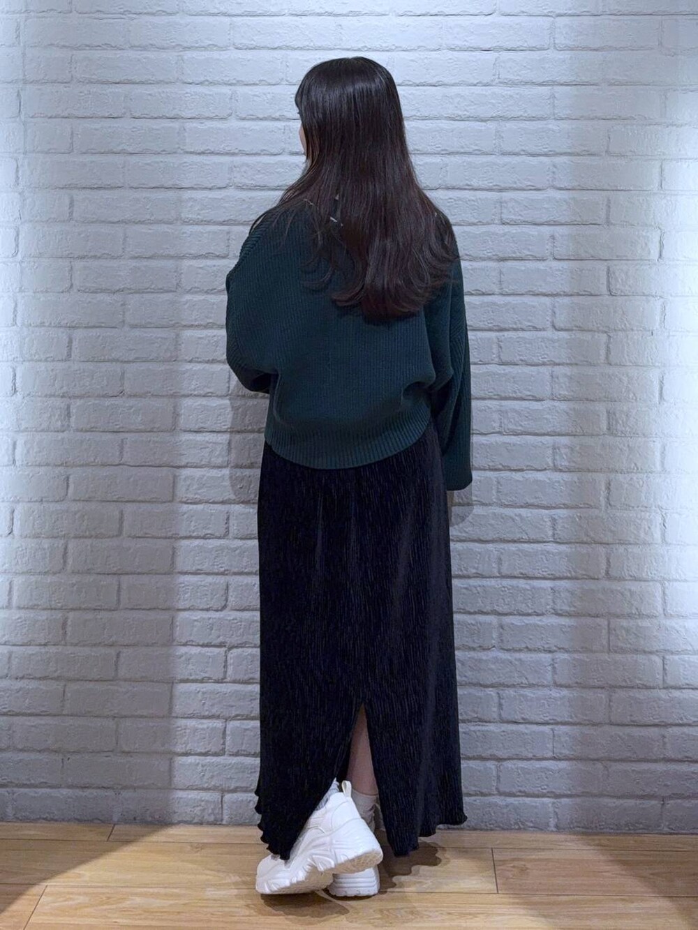 シルバー系のタンクトップ、グリーン系のカーディガン/ボレロ、ホワイト系のスニーカーを着用したレディースの秋コーディネートの4枚目の写真