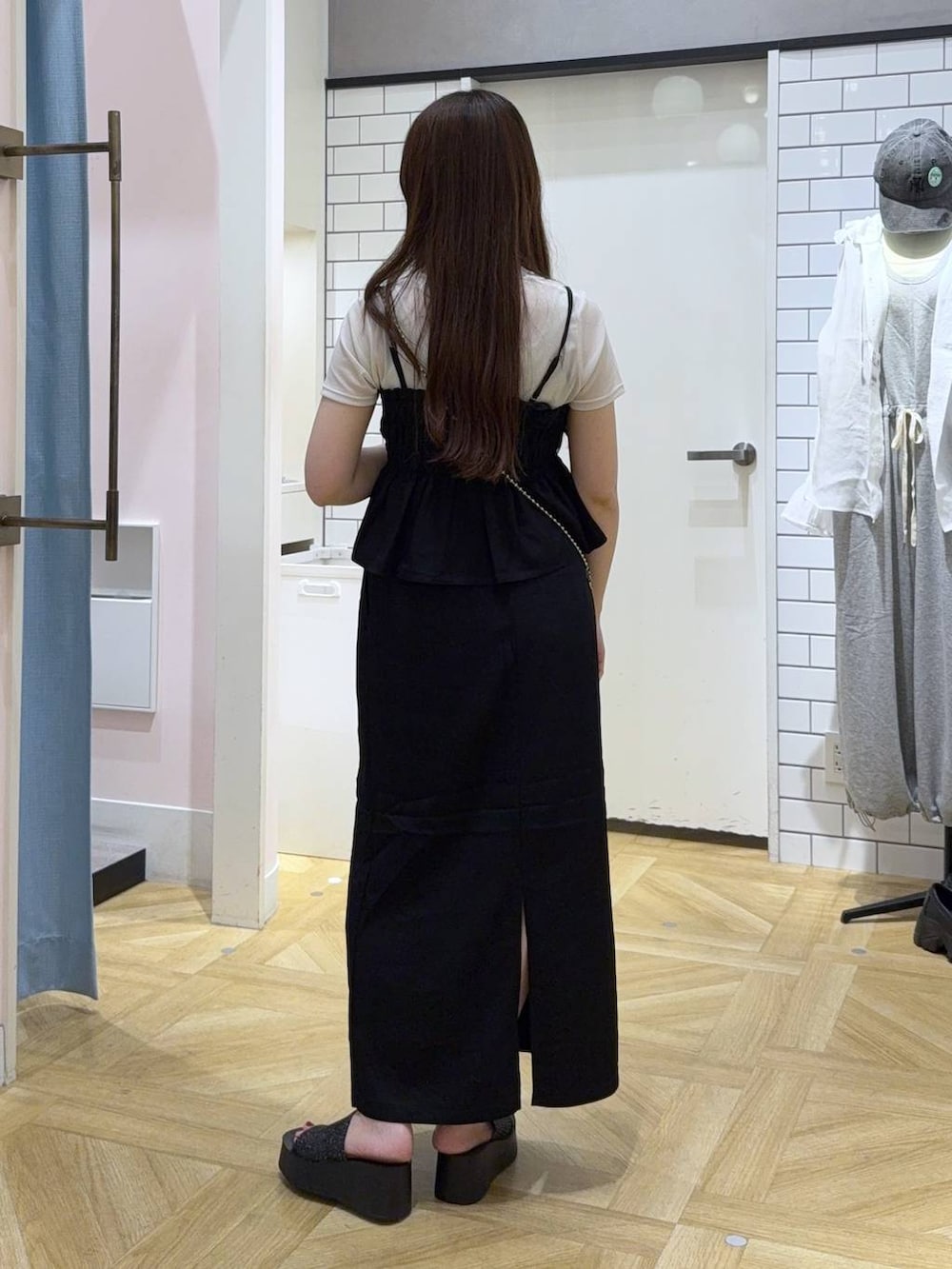 シルバー系のショルダーバッグ、ブラック系のスカート、ホワイト系のTシャツ/カットソーを着用したレディースの秋コーディネートの5枚目の写真