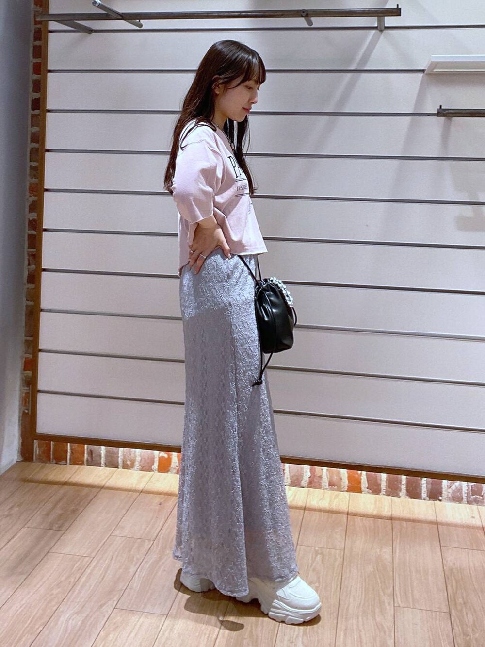 ピンク系のTシャツ/カットソー、グレー系のスカート、ブラック系のショルダーバッグを着用したレディースの夏コーディネートの3枚目の写真