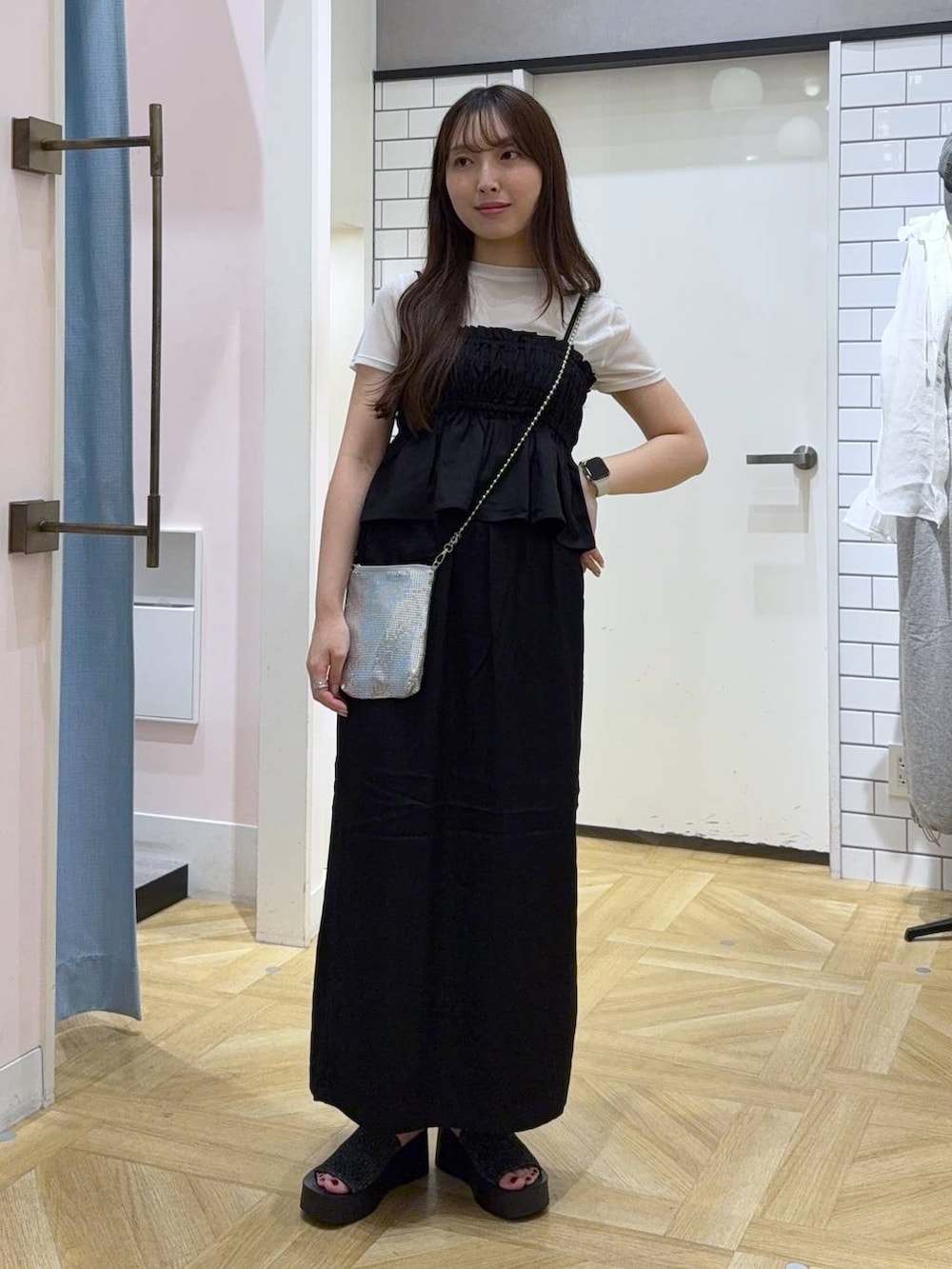シルバー系のショルダーバッグ、ブラック系のスカート、ホワイト系のTシャツ/カットソーを着用したレディースの秋コーディネートの2枚目の写真