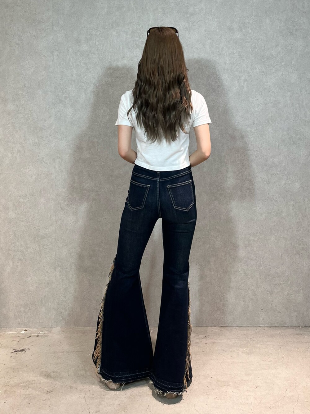 ホワイト系のTシャツ/カットソー、ブルー系のデニムパンツ、ホワイト系のサンダルを着用したレディースの春コーディネートの4枚目の写真