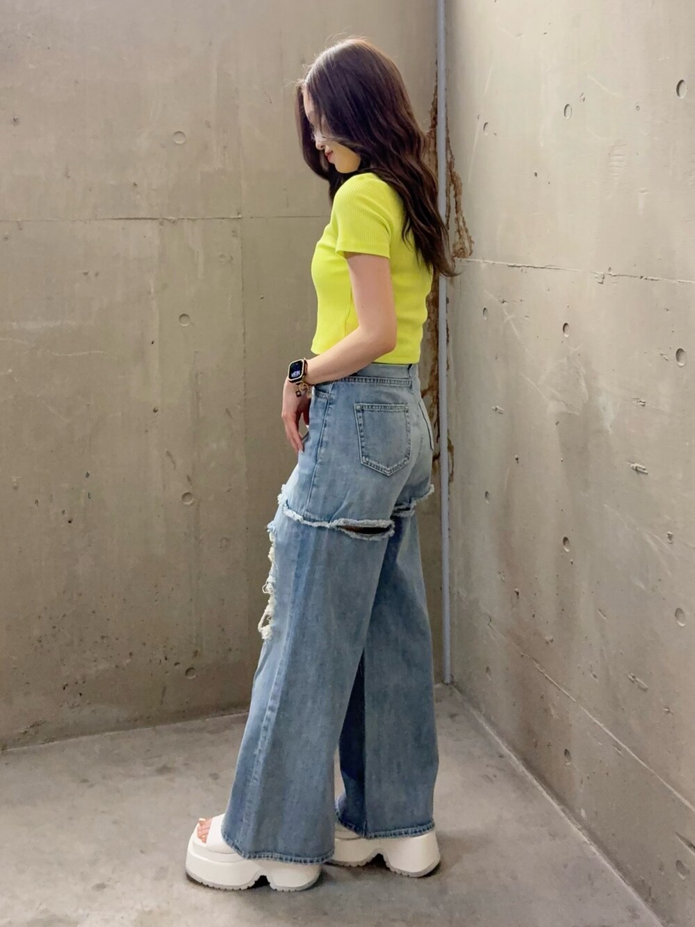 ブルー系のデニムパンツ、ホワイト系のサンダル、グリーン系のTシャツ/カットソーを着用したレディースの春コーディネートの2枚目の写真