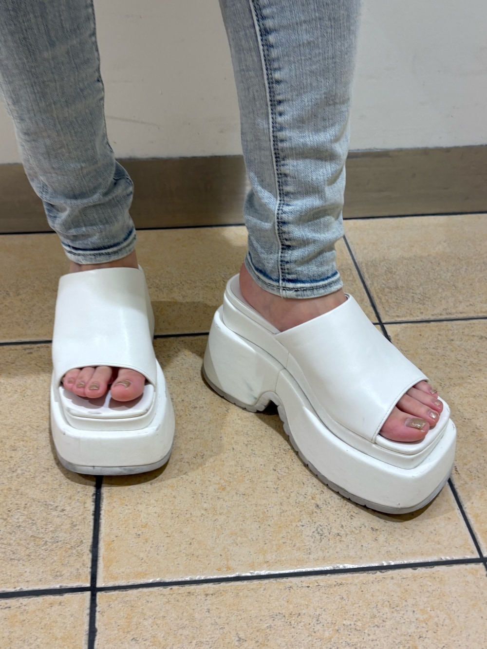 ホワイト系のTシャツ/カットソー、ブルー系のデニムパンツ、ホワイト系のサンダルを着用したレディースの夏コーディネートの6枚目の写真