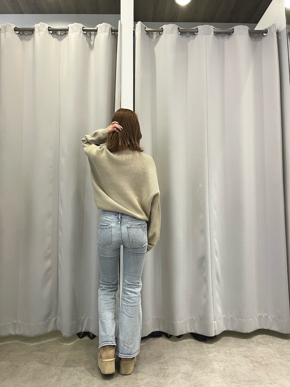 ホワイト系のダウンジャケット/コート、ベージュ系のニット/セーター、ブルー系のデニムパンツを着用したレディースの冬コーディネートの4枚目の写真