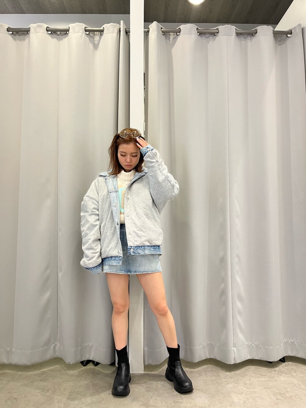 ブルー系のデニムジャケット、ホワイト系のニット/セーター、ブルー系のデニムスカートを着用したレディースの冬コーディネートの3枚目の写真