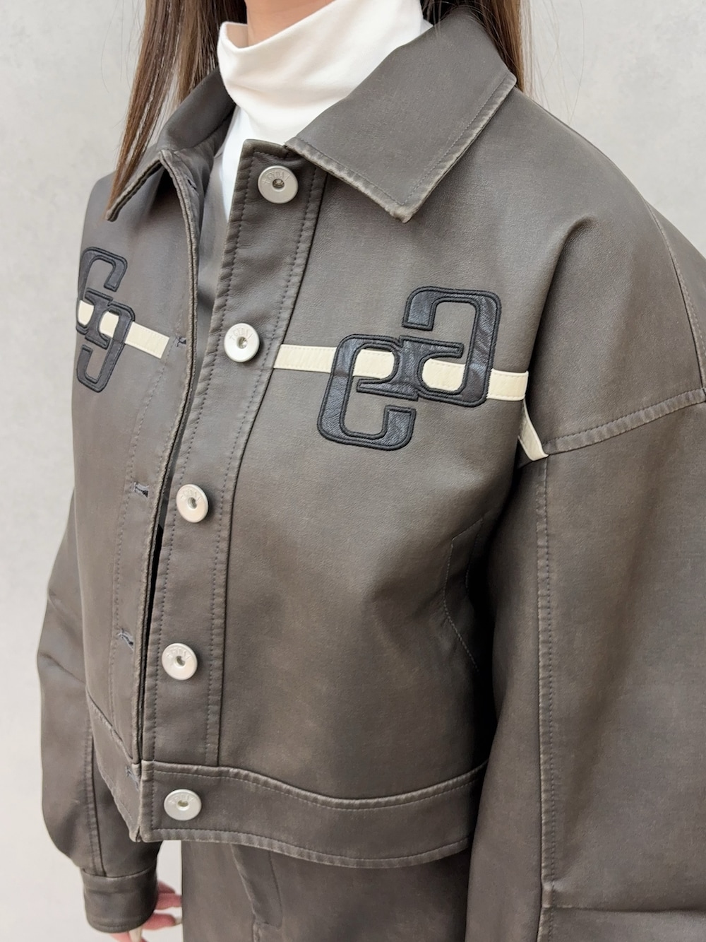 ホワイト系のTシャツ/カットソー、ブラック系のブーツ、ブラウン系のブルゾンを着用したレディースの冬コーディネートの4枚目の写真