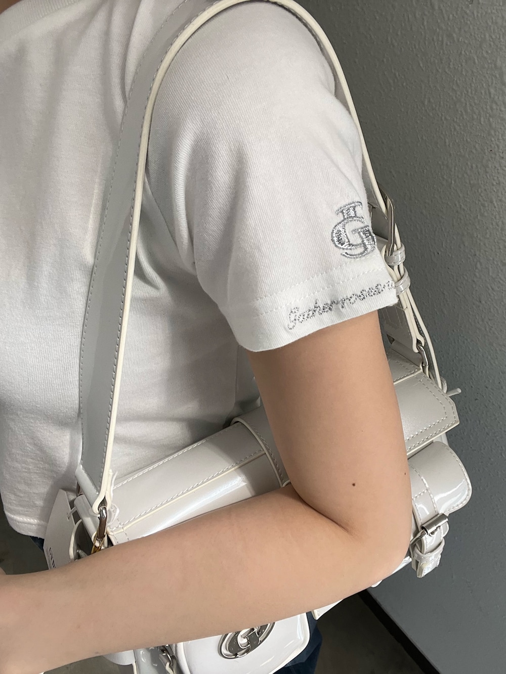 ホワイト系のTシャツ/カットソー、ホワイト系のハンドバッグ、ブルー系のデニムパンツを着用したレディースの春コーディネートの5枚目の写真