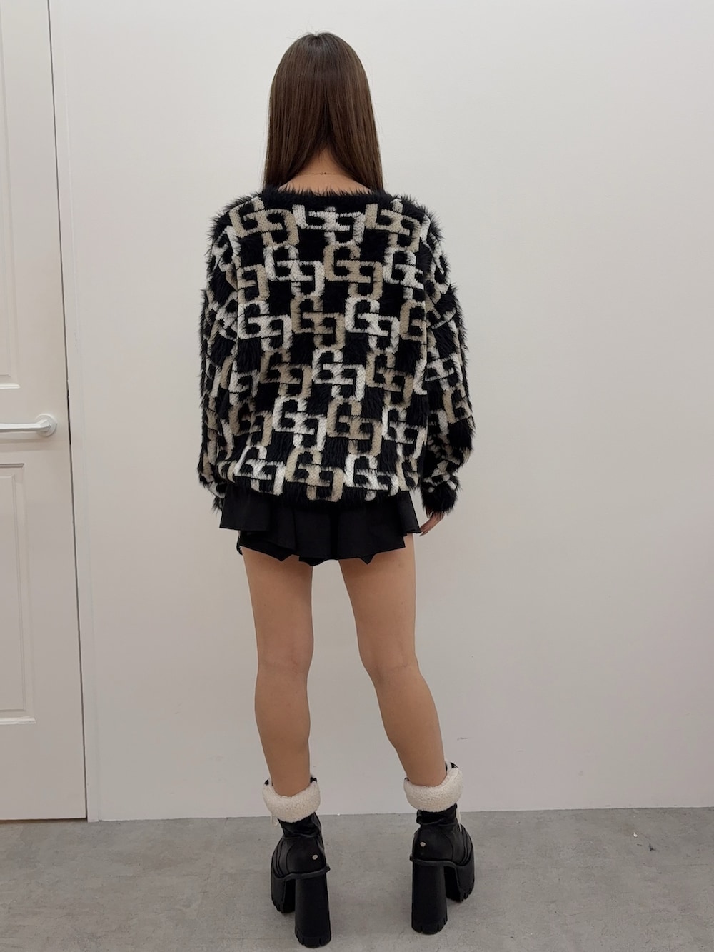 ブラック系のニット/セーター、ブラック系のブーツ、ブラック系のスカートを着用したレディースの冬コーディネートの3枚目の写真