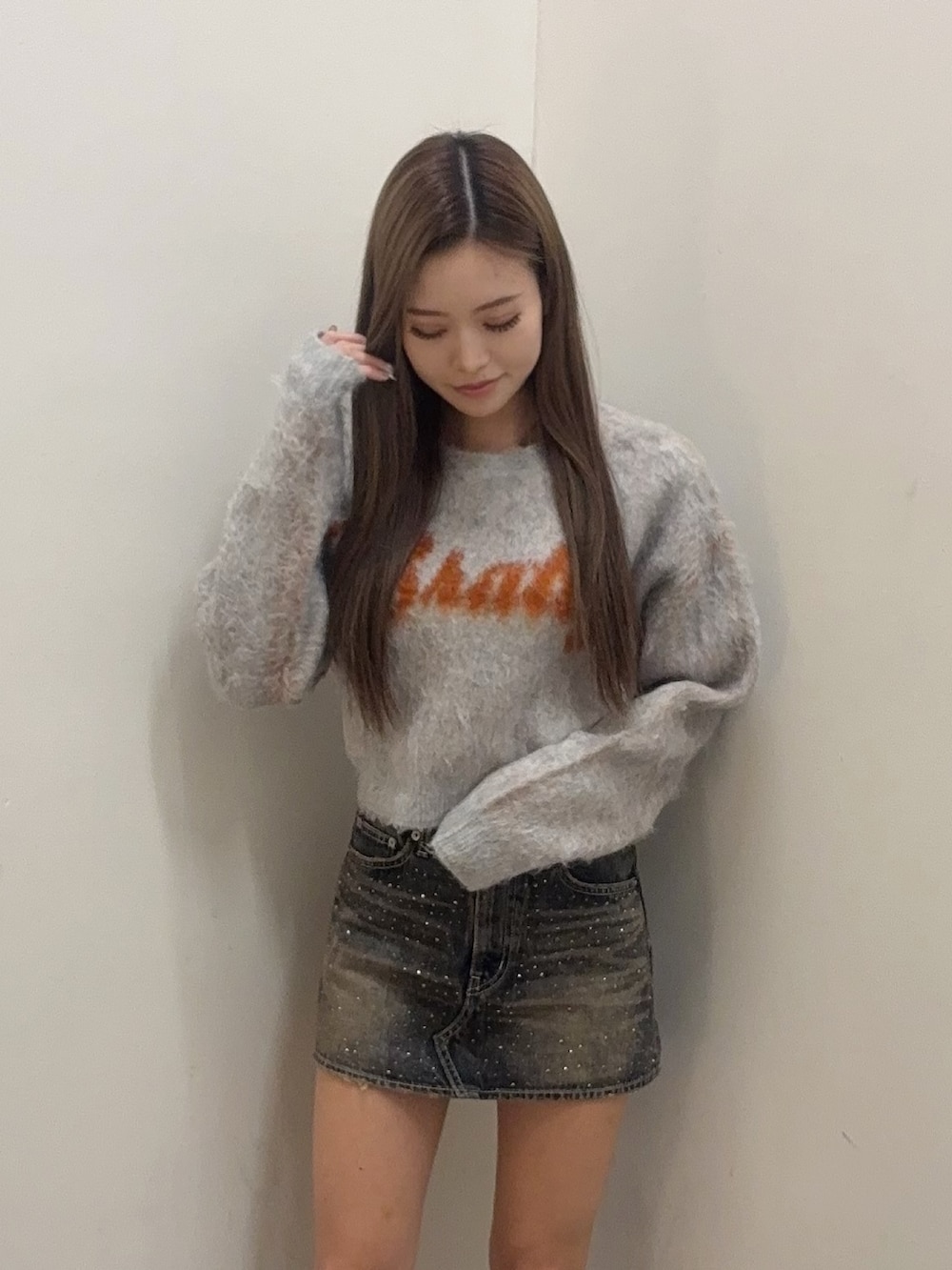 グレー系のニット/セーター、ブルー系のデニムスカート、ブラック系のブーツを着用したレディースの冬コーディネートの4枚目の写真