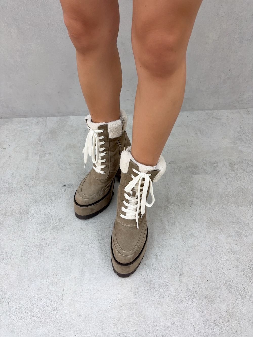 ピンク系のパーカー、ブルー系のデニムスカート、ベージュ系のブーツを着用したレディースの秋コーディネートの6枚目の写真