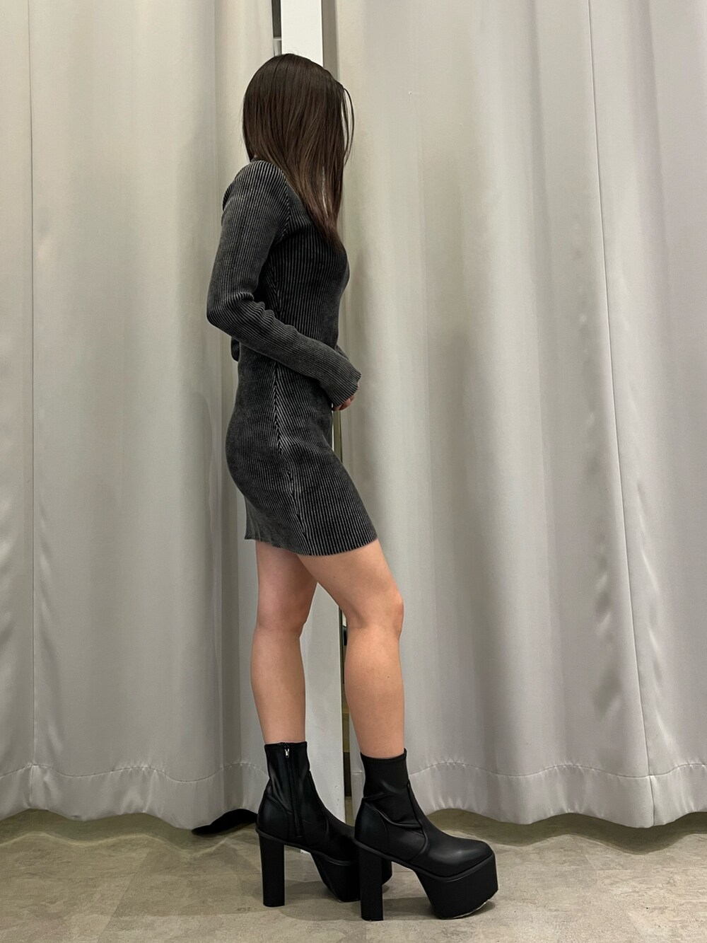 ブラック系のワンピース、ブラック系のブーツを着用したレディースの春コーディネートの2枚目の写真