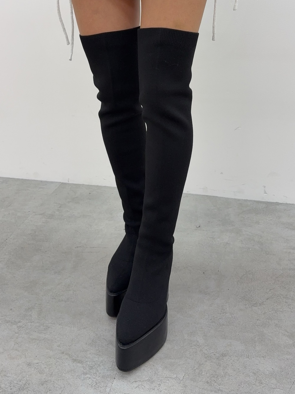 ブルー系のデニムスカート、ブラック系のブーツ、ピンク系のTシャツ/カットソーを着用したレディースの冬コーディネートの5枚目の写真