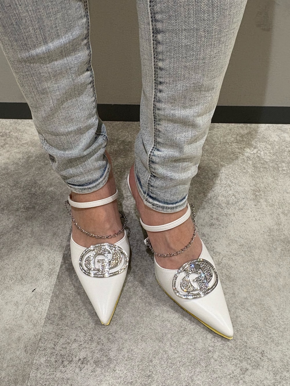 シルバー系のニット/セーター、ブルー系のデニムパンツ、ホワイト系のパンプスを着用したレディースの春コーディネートの7枚目の写真